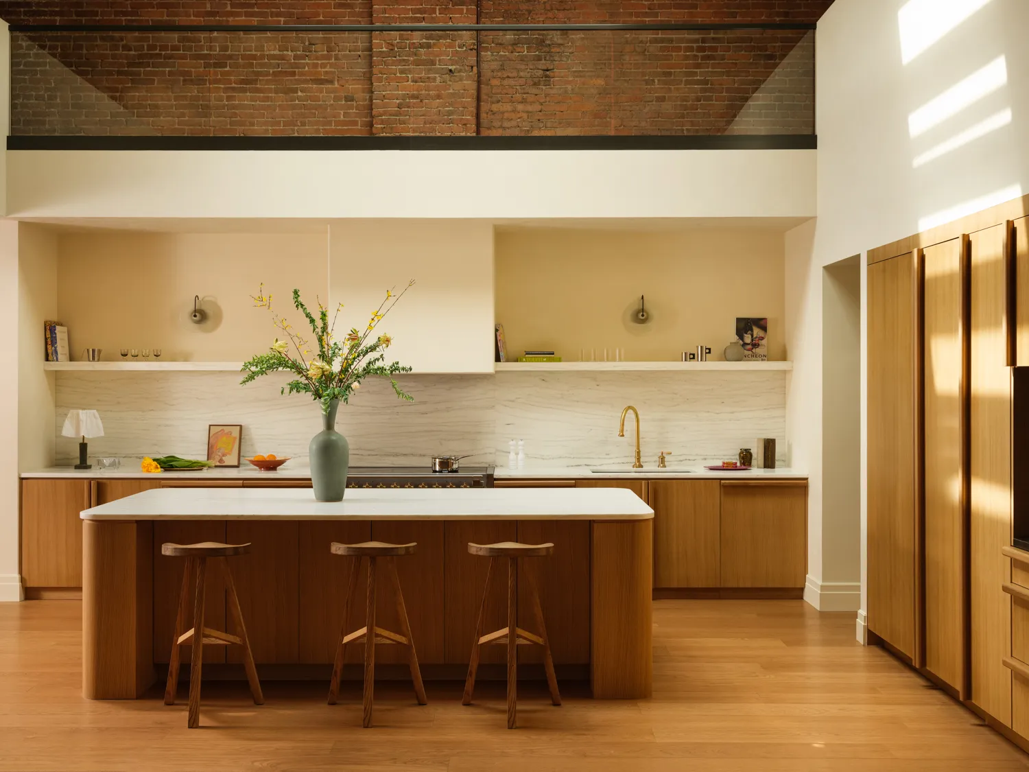Custom wood kitchen cabinetry with a large island by MEBEL CABINETS